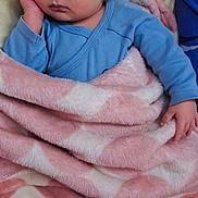 Rayan participe au concours pour gagner de l'argent avec cette photo : baby, infant, sleeping, blanket, blue_onesie, cozy, hand, face, bedding, soft_texture, pillow, newborn, portrait, plush_blanket, peaceful, relaxed, nap, bedside, skin, cute