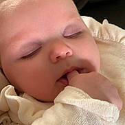June participe au concours pour gagner de l'argent avec cette photo : baby, sleeping, finger_in_mouth, cozy, soft, infant, closeup, face, cute, child, clothing, pale_skin, peaceful, indoors, portrait, young, relaxed, expression, head, resting
