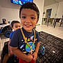 child, smiling, indoor, living_room, toy, television, mirror, carpet, furniture, gold_chain, tshirt, shorts, socks, person, happy, play, background, floor, blur, kid