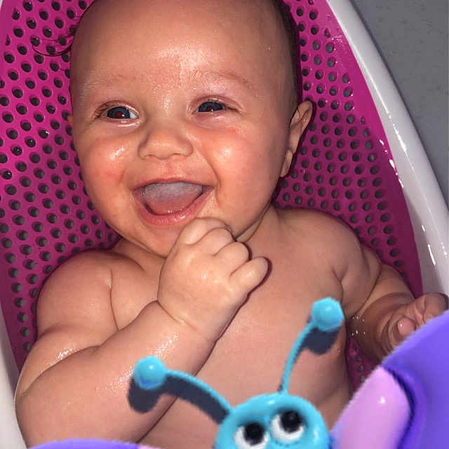 Amelia James joined the competition — help win amazing prizes! baby, bath, bathtub, blue, butterfly_toy, child, closeup, cute, happy, indoors, infant, laughing, pink, playful, purple, sitting, smiling, toy, water, wet_skin