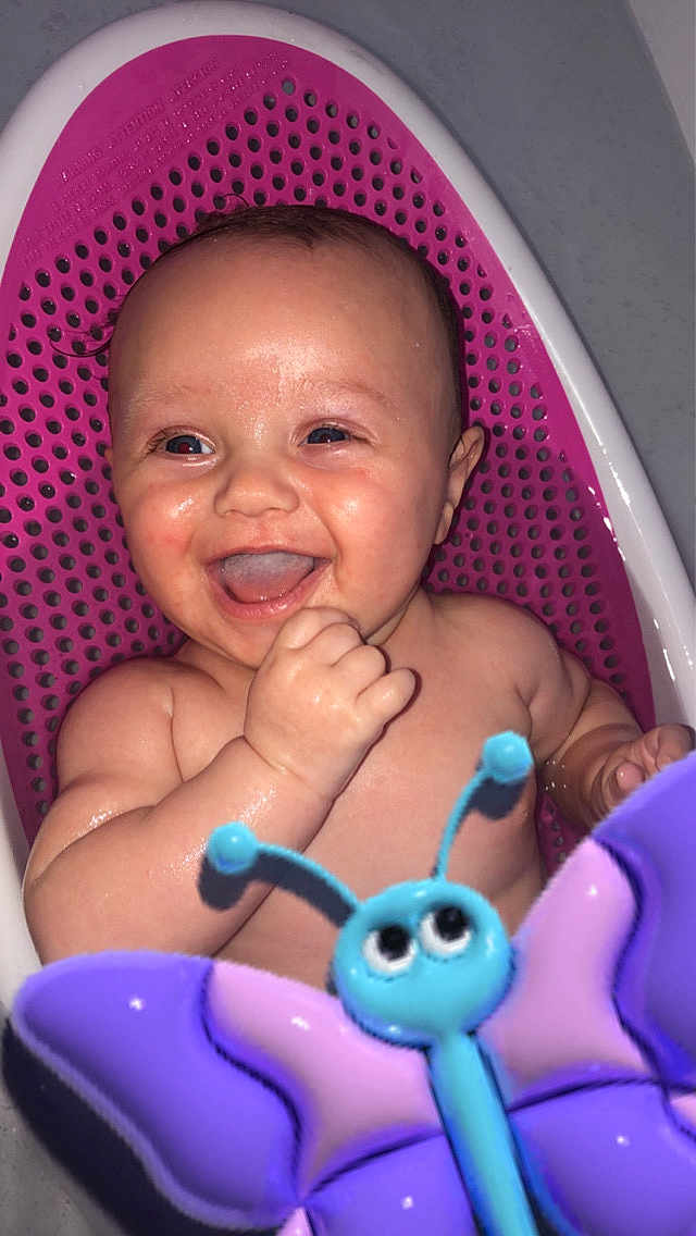 Amelia James joined the competition — help win amazing prizes! baby, child, smiling, laughing, bath, bathtub, toy, butterfly_toy, water, wet_skin, pink, purple, blue, happy, infant, cute, playful, sitting, indoors, closeup