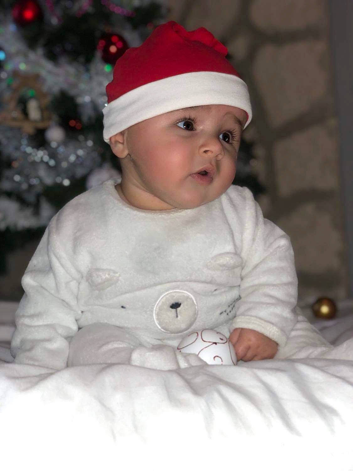 Mathis participe au concours pour gagner de l'argent avec cette photo : baby, baby_toddler_clothing, cap, carmine, child, christmas, costume_hat, event, happy, hat, head, headgear, headwear, holiday, human_body, person, santa_claus, sitting, sleeve, toddler
