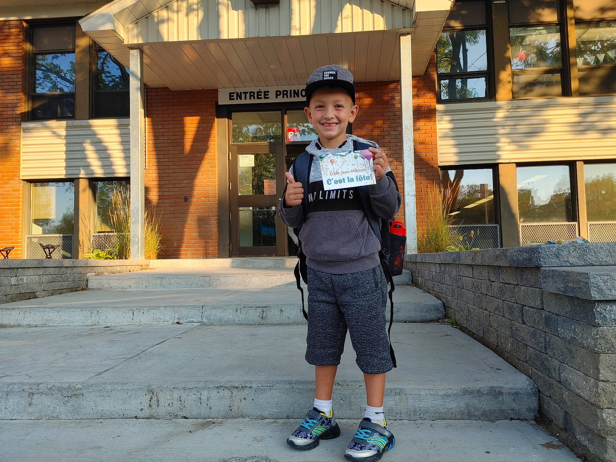 Ryan a rejoint le concours — aidez-le/la à gagner de superbes lots ! asphalt, cap, city, electric_blue, facade, fun, hat, headwear, joy, leisure, pedestrian, person, public_space, recreation, road, shorts, sidewalk, smile, street, street_fashion