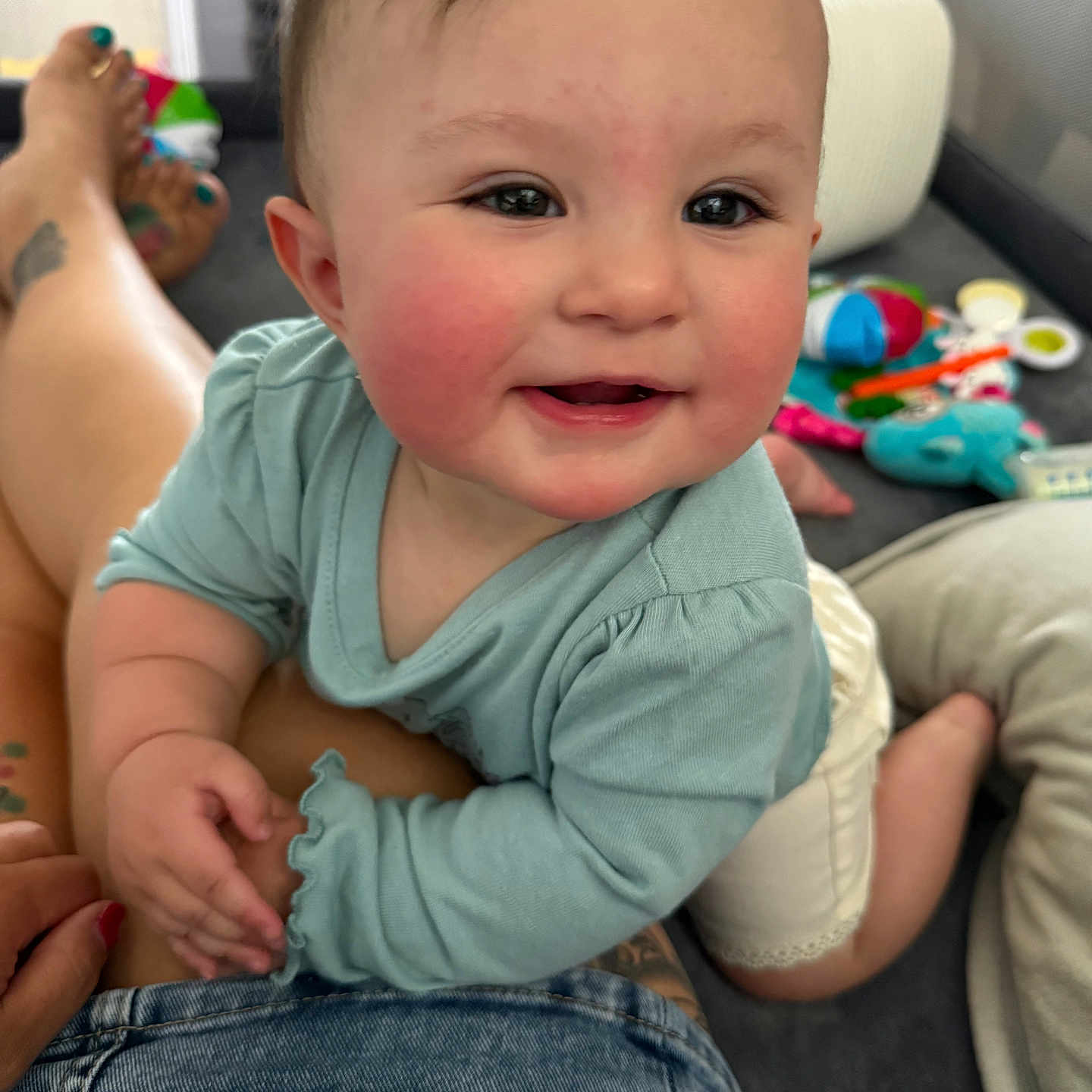Emma joined the competition — help win amazing prizes! baby, child, smile, rosy_cheeks, indoor, toys, play_area, person, clothing, legs, denim, hand, face, happy, curious, infant, closeup, home, crawling, bright