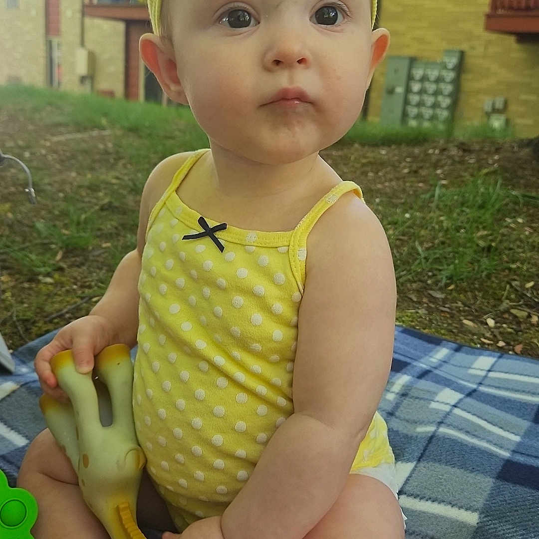Nalani is registered to the contest to win money with this photo: architecture, baby, backyard, building, cap, clothing, face, grass, hat, head, nature, outdoors, person, photography, plant, portrait, shelter, sitting, summer, yard
