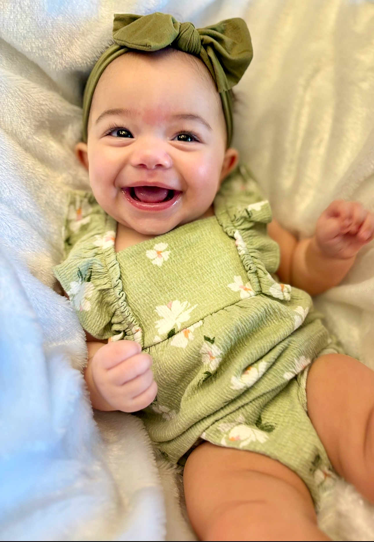 Anlyn joined the competition — help win amazing prizes! baby, smiling, green_headband, green_outfit, floral_pattern, blanket, happy, cute, infant, portrait, child, soft_texture, lying_down, close_up, skin, hand, face, head, eyes, mouth