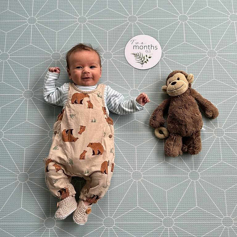 Rian joined the competition — help win amazing prizes! baby, blanket, clothing, doll, dress, face, happy, head, homedecor, newborn, pajamas, pants, person, photography, plush, portrait, sitting, sleeve, teddybear, toy