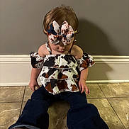 Brooklynn joined the competition — help win amazing prizes! toddler, child, indoor, sitting, floor, tile, bow, hair_accessory, clothing, pants, top, pattern, cow_print, shoes, brown_shoes, pink_sole, wall, baseboard, shadow, cute