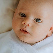 Lewis participe au concours pour gagner de l'argent avec cette photo : baby, blanket, child, closeup, cozy, cute, expression, eyes, face, head, indoors, infant, newborn, person, portrait, skin, sleepwear, soft, warm, white
