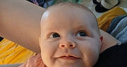 Sommer is registered to the contest to win money with this photo: arm, baby, blanket, child, clothing, cozy, curious, cute, expression, face, floor, furniture, home, indoor, infant, person, pink_outfit, portrait, slippers, smile