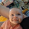Sommer is registered to the contest to win money with this photo: baby, infant, smile, face, person, child, arm, clothing, pink_outfit, indoor, home, floor, slippers, furniture, blanket, cozy, cute, portrait, expression, curious