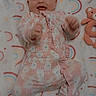 Sommer is registered to the contest to win money with this photo: baby, blanket, child, cozy, cute, floor, happy, indoors, infant, lying_down, monkey_pattern, onesie, playful, plush_toy, rainbow_pattern, small_hands, smiling, soft_texture, teddy_bear, young