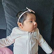 Kendra Charlotte a rejoint le concours — aidez-le/la à gagner de superbes lots ! baby, infant, headband, pink, white_clothing, couch, indoor, portrait, face, child, young, cute, cozy, soft, relaxed, side_view, small_ears, dark_hair, sitting, expression