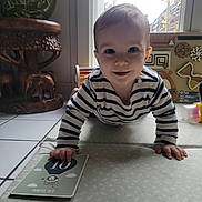 Adam a rejoint le concours — aidez-le/la à gagner de superbes lots ! baby, child, crawling, milestone_card, striped_clothing, drooling, indoor, soft_mat, toy, wooden_table, window, natural_light, floor_tiles, smiling, person, head, hand, face, home, cute