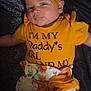 baby, infant, bow, headband, yellow, shirt, clothing, floral, shorts, lying_down, blanket, cute, child, portrait, face, skin, person, adorable, calm, indoors