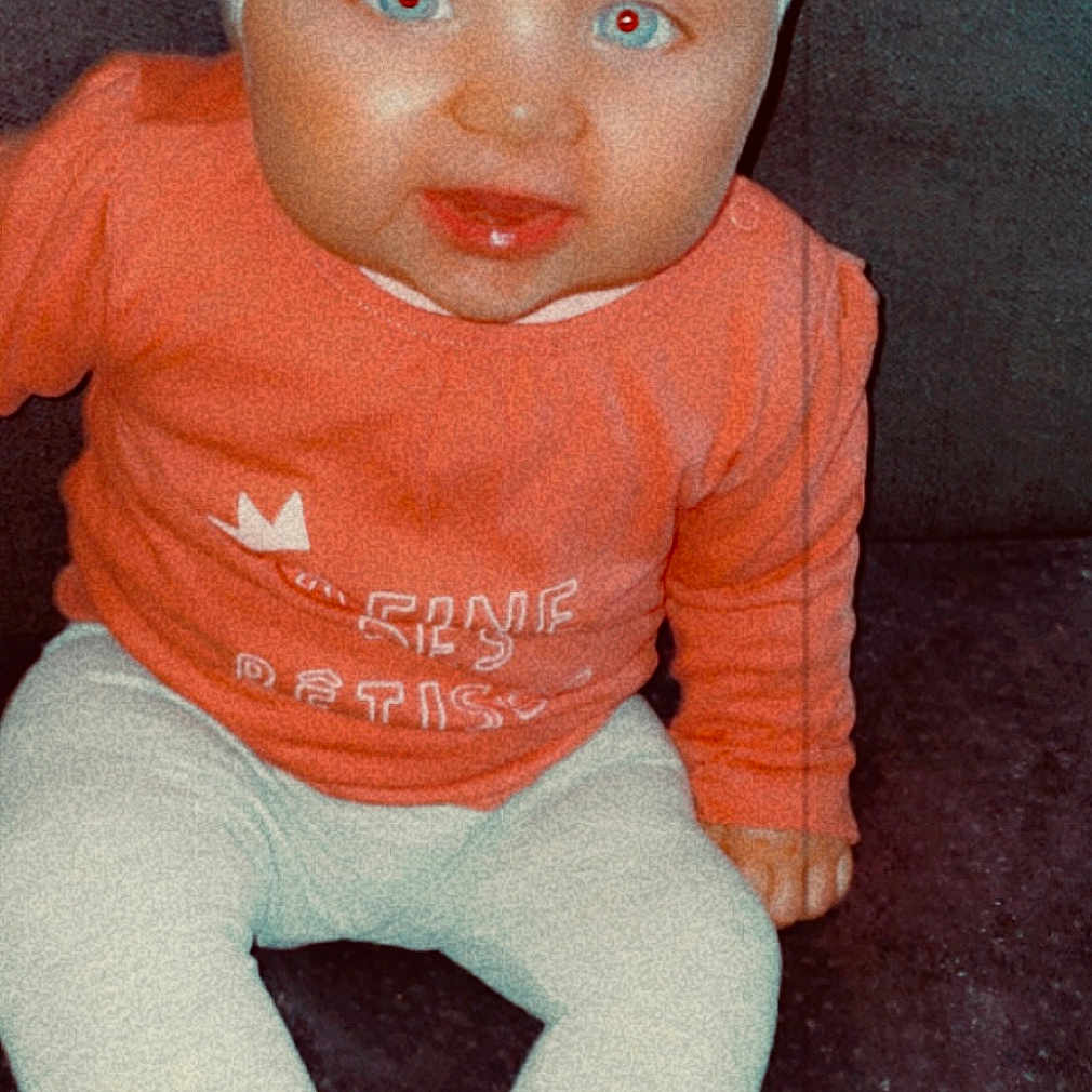 Laila participe au concours pour gagner de l'argent avec cette photo : accessories, baby, bonnet, cap, clothing, couch, cushion, face, furniture, hat, head, headband, jeans, newborn, pants, person, photography, portrait, sitting, toy
