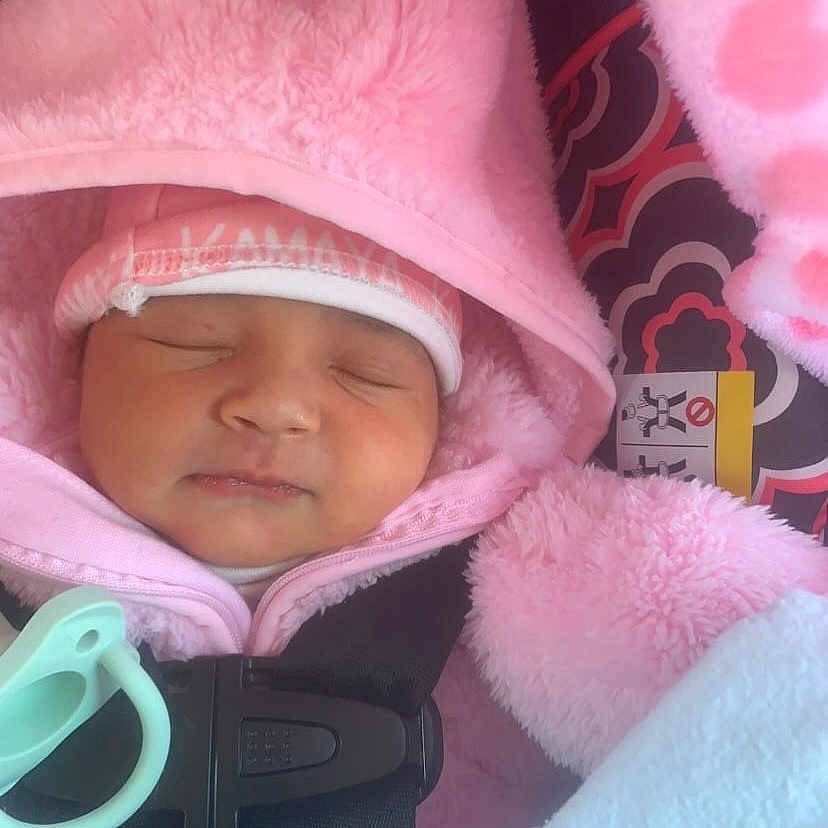 Kamaya is registered to the contest to win money with this photo: baby, blanket, bonnet, cap, clothing, coat, face, glove, gun, hat, head, hood, jacket, newborn, person, photography, portrait, purple, sleeping, weapon