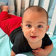Thiago joined the competition — help win amazing prizes! baby, child, infant, portrait, face, eyes, smiling, happy, crib, bed, blanket, pajamas, black_clothing, red_clothing, indoor, close_up, sitting, lying_down, hand, nursery