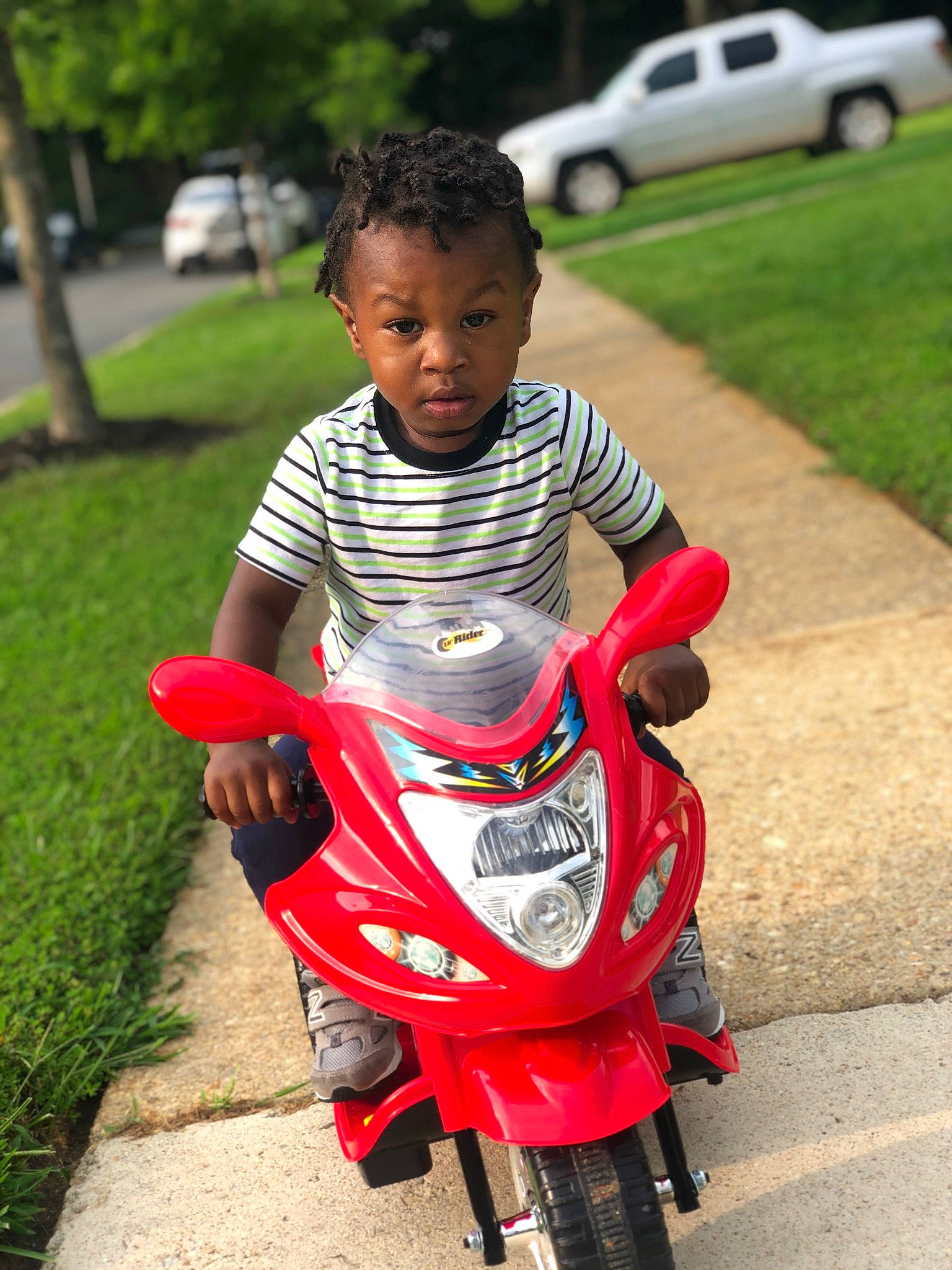 Jamir is registered to the contest to win money with this photo: automotive_design, automotive_lighting, automotive_tire, automotive_wheel_system, baby, car, fender, fun, grass, happy, head, human_body, land_vehicle, motor_vehicle, person, recreation, rim, tire, travel, vehicle