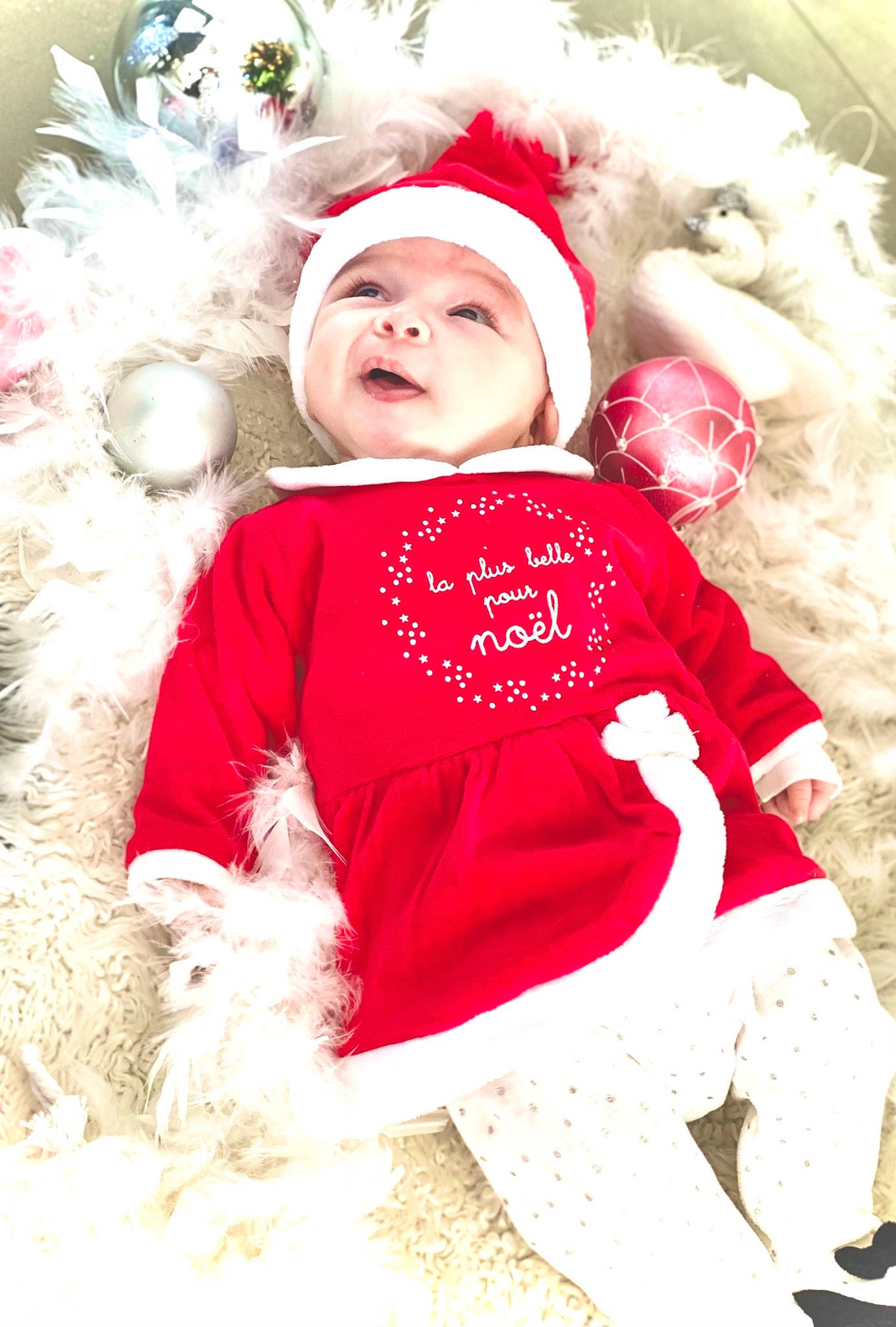 Mila a rejoint le concours — aidez-le/la à gagner de superbes lots ! baby, baby_toddler_clothing, child, child_model, christmas, christmas_eve, costume, costume_accessory, costume_hat, fictional_character, fur, fur_clothing, headgear, headwear, holiday, human, person, red, shoe, skin