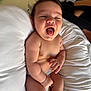 arm, baby, child, chubby, cute, diaper, expression, hair, hand, indoors, infant, joy, leg, newborn, person, pillow, skin, smiling, tongue_out, white