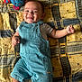 Hayden a rejoint le concours — aidez-le/la à gagner de superbes lots ! baby, bedspread, child, clothing, cute, face, happy, indoors, infant, lying_down, overalls, patterned_blanket, playful, plush_toy, portrait, resting, smiling, sock, toy, young_child