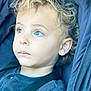 Lucciano a rejoint le concours — aidez-le/la à gagner de superbes lots ! toddler, child, face, curly_hair, green_eyes, portrait, closeup, blue_clothing, seat, stroller, car_seat, young_child, expression, looking_away, indoors, soft_light, casual_clothing, person, baby, cute