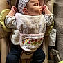 baby, sleeping, headband, bib, baby_rocker, cushion, clothing, footwear, infant, peaceful, indoor, portrait, child, soft_texture, fabric, closeup, cute, relaxation, resting, small_person
