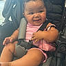 baby, child, stroller, pink_clothing, smile, happy, infant, seatbelt, purse, cute, indoors, chubby_cheeks, person, young_child, sitting, hand, foot, black_stroller, casual, relaxed
