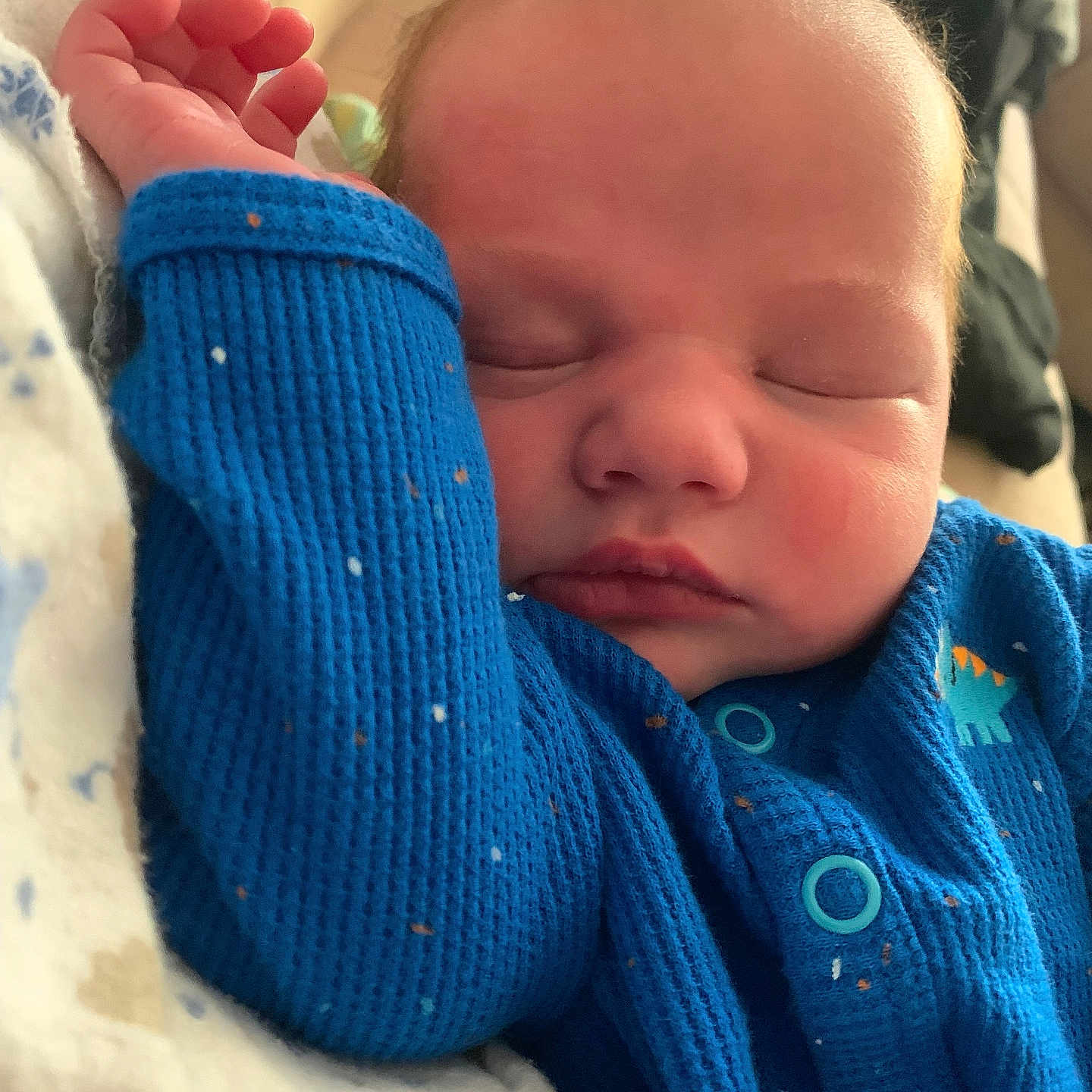 Keaton is registered to the contest to win money with this photo: baby, blanket, blue_onesie, buttoned_clothing, child, closeup, cozy, cute, face, hand, indoor, infant, newborn, peaceful, portrait, resting, skin, sleeping, soft_light, young