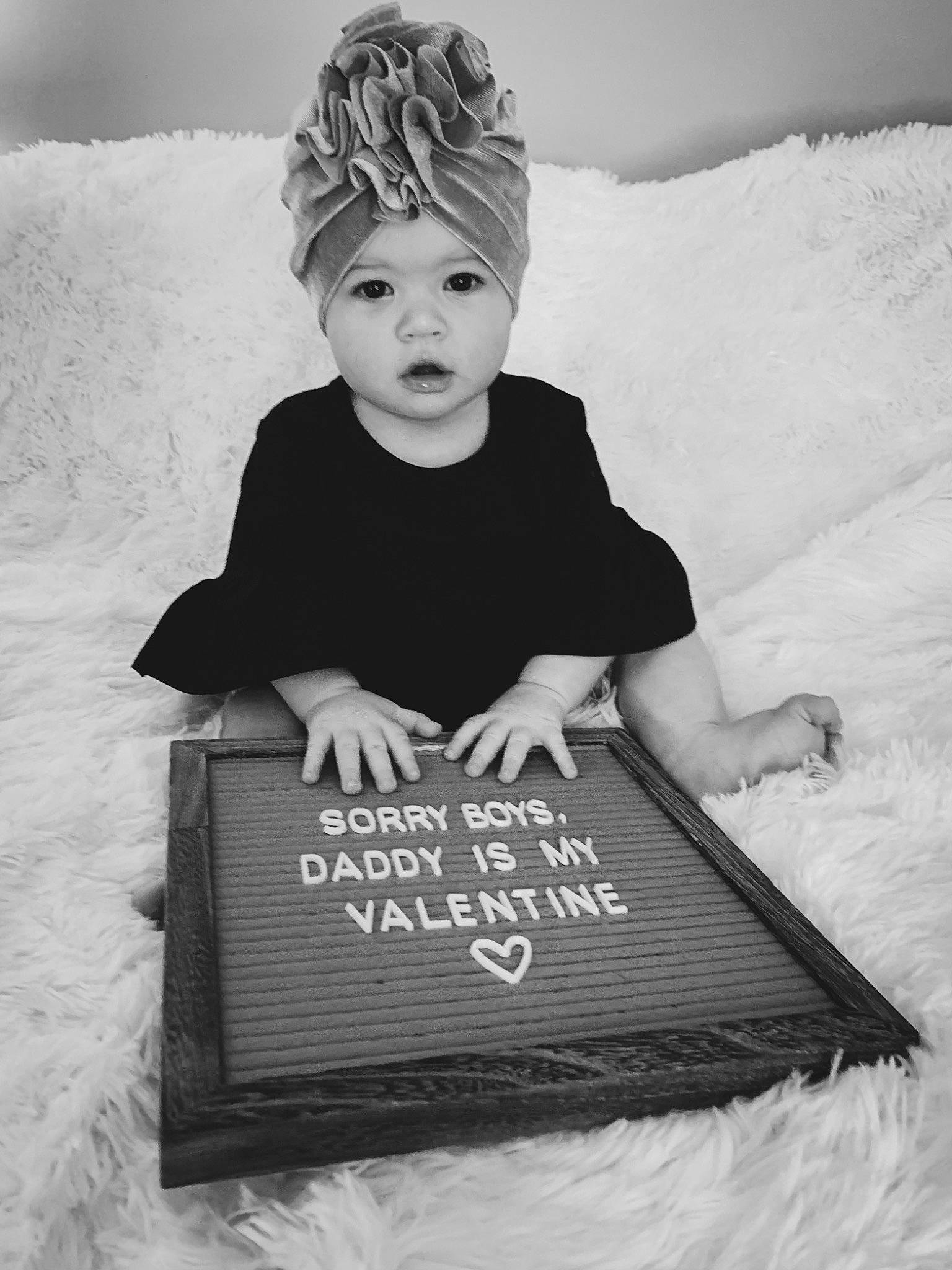 Kimber is registered to the contest to win money with this photo: baby, black, black_and_white, cap, child, cool, flash_photography, font, happy, headgear, headwear, monochrome, monochrome_photography, person, photograph, sitting, sleeve, style, t_shirt, toddler