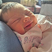 Robyn joined the competition — help win amazing prizes! baby, newborn, smile, sleeping, infant, cute, face, clothing, pink, floral_pattern, close_up, soft_light, indoor, portrait, peaceful, resting, child, person, cute_expression, warm