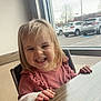 toddler, child, smile, indoor, window, table, wood, hair, happy, face, clothing, long_sleeve, pink, chair, hand, parking_lot, car, daylight, casual, person