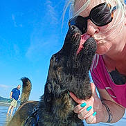 Taïko a rejoint le concours — aidez-le/la à gagner de superbes lots ! dog, german_shepherd, woman, kiss, sunglasses, nail_polish, beach, water, happy, tattoo, blue_sky, sunny, outdoor, person, man, leash, harness, barefoot, summer, playful