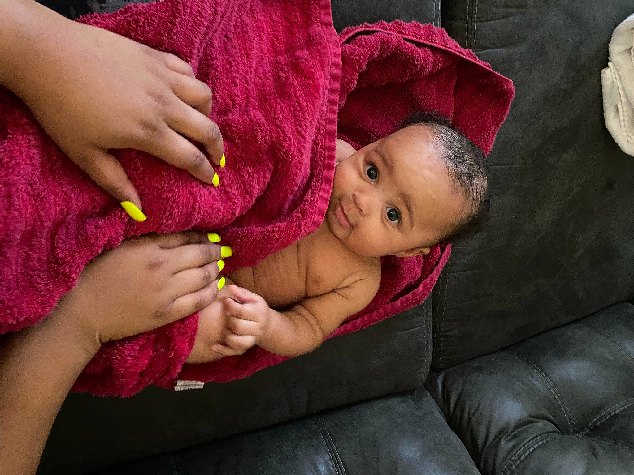 Journey is registered to the contest to win money with this photo: arm, baby, child, comfort, couch, face, gesture, hand, human_body, mouth, nail, person, pink, purple, red, skin, textile, thigh, thumb, toddler