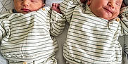 Wassim Et Qassim a rejoint le concours — aidez-le/la à gagner de superbes lots ! twins, newborn, baby, infant, sleeping, smiling, matching_outfits, striped_pajamas, blanket, bed, cozy, hand_holding, sibling, portrait, cute, soft_lighting, close_up, white_sheet, socks, nursery