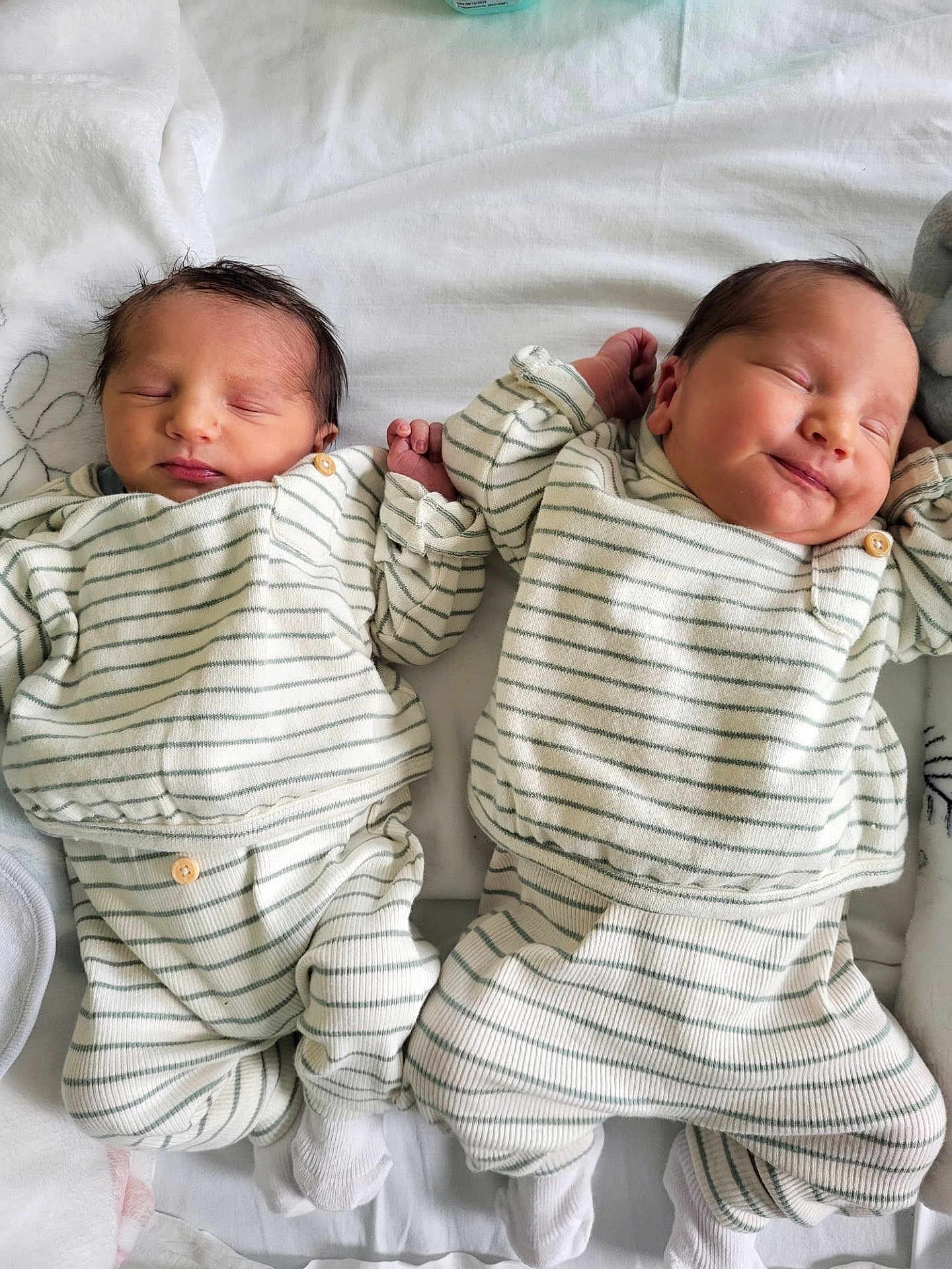 Wassim Et Qassim a rejoint le concours — aidez-le/la à gagner de superbes lots ! twins, newborn, baby, infant, sleeping, smiling, matching_outfits, striped_pajamas, blanket, bed, cozy, hand_holding, sibling, portrait, cute, soft_lighting, close_up, white_sheet, socks, nursery