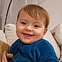 Lena a rejoint le concours — aidez-le/la à gagner de superbes lots ! baby, blue_clothing, child, closeup, couch, cozy, cute, face, happy, home, indoors, infant, person, pillow, portrait, seated, smile, soft_texture, warm_lighting, young_child