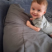 Ian is registered to the contest to win money with this photo: baby, bed, child, clothing, cute, eyes, face, gray, hair, hand, happy, headboard, indoors, infant, person, pillow, portrait, skin, smiling, toddler