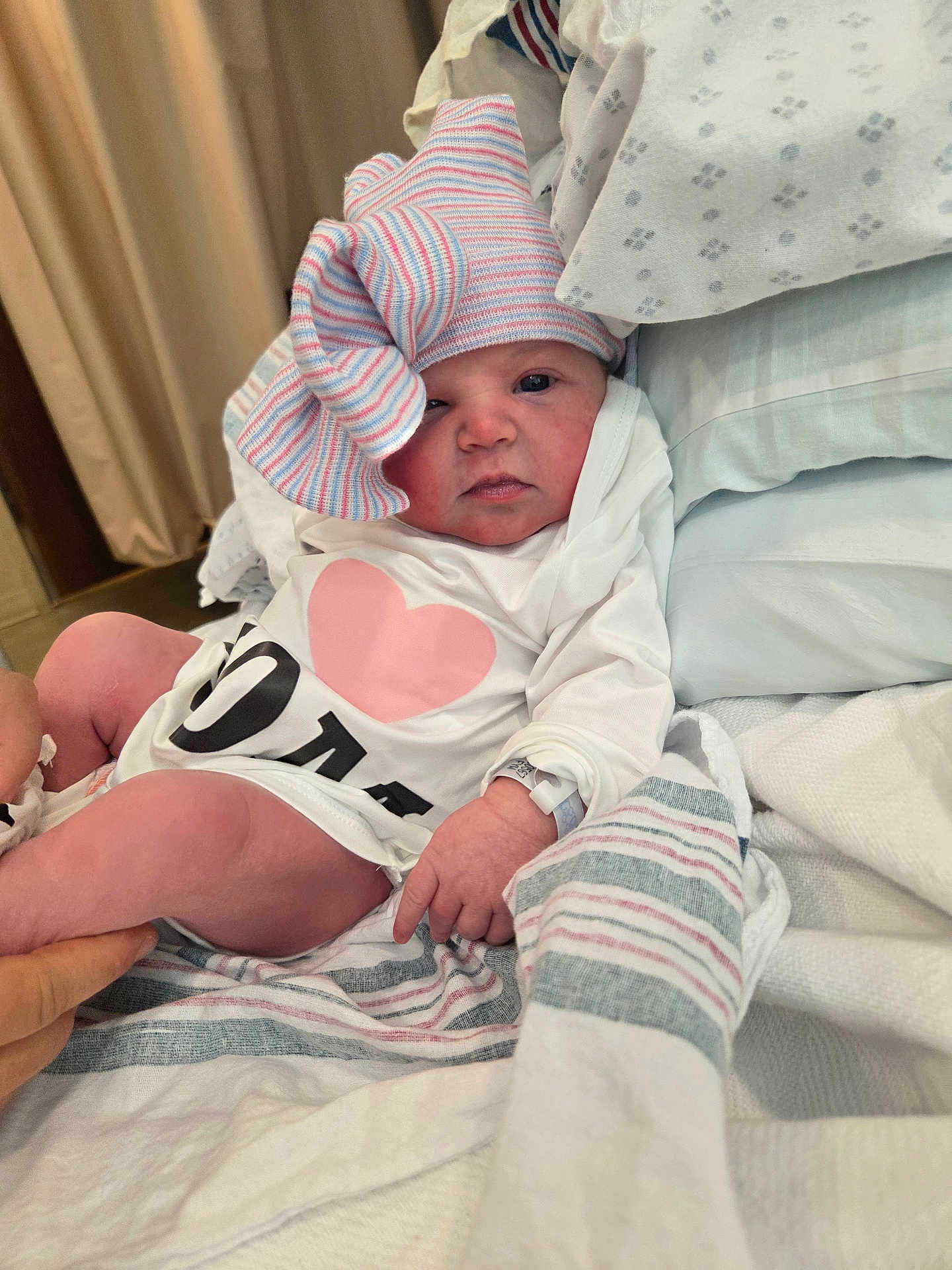 Ariel joined the competition — help win amazing prizes! baby, newborn, onesie, striped_hat, hospital_blanket, wristband, pillow, bed, blanket, hand, leg, curtain, pink, white, portrait, infant, clothing, cute, sleepy, hospital_room