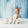 baby, blue_background, child, cute, face, first_birthday, fluffy_carpet, girl, hair_bows, happy, indoor, infant, one_sign, person, pigtails, portrait, sitting, smiling, studio_photo, white_box