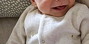 Oscar a rejoint le concours — aidez-le/la à gagner de superbes lots ! baby, infant, smile, joy, pajamas, soft_toy, cushion, pattern, hand, face, child, cozy, cute, lying_down, indoors, happy, closeup, skin, expression, warm