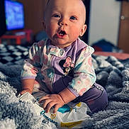 Lakelynn joined the competition — help win amazing prizes! baby, child, infant, onesie, mickey_mouse, blanket, soft, indoor, cute, curious, sitting, hand, face, expression, pampers, packaging, blue_eyes, fingertips, clothing, home