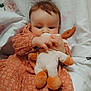 Naïa participe au concours pour gagner de l'argent avec cette photo : baby, infant, child, plush_toy, stuffed_animal, blanket, floral_pattern, dress, orange_dress, toes, bed, bedding, portrait, hand, eyes, cute, cozy, indoor, holding_toy, reclining