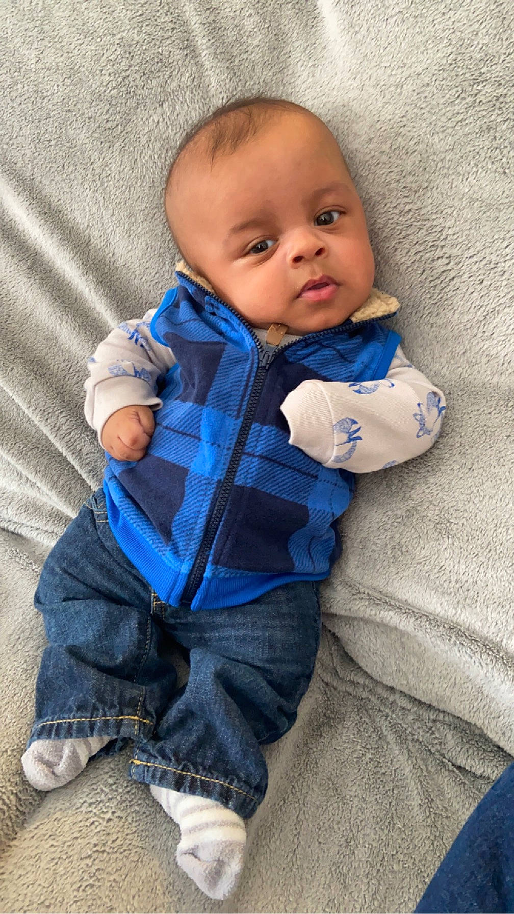 Harlem is registered to the contest to win money with this photo: azure, baby, baby_toddler_clothing, cheek, child, comfort, electric_blue, face, flooring, fur, grey, linens, outerwear, pattern, person, purple, sitting, skin, sleeve, toddler