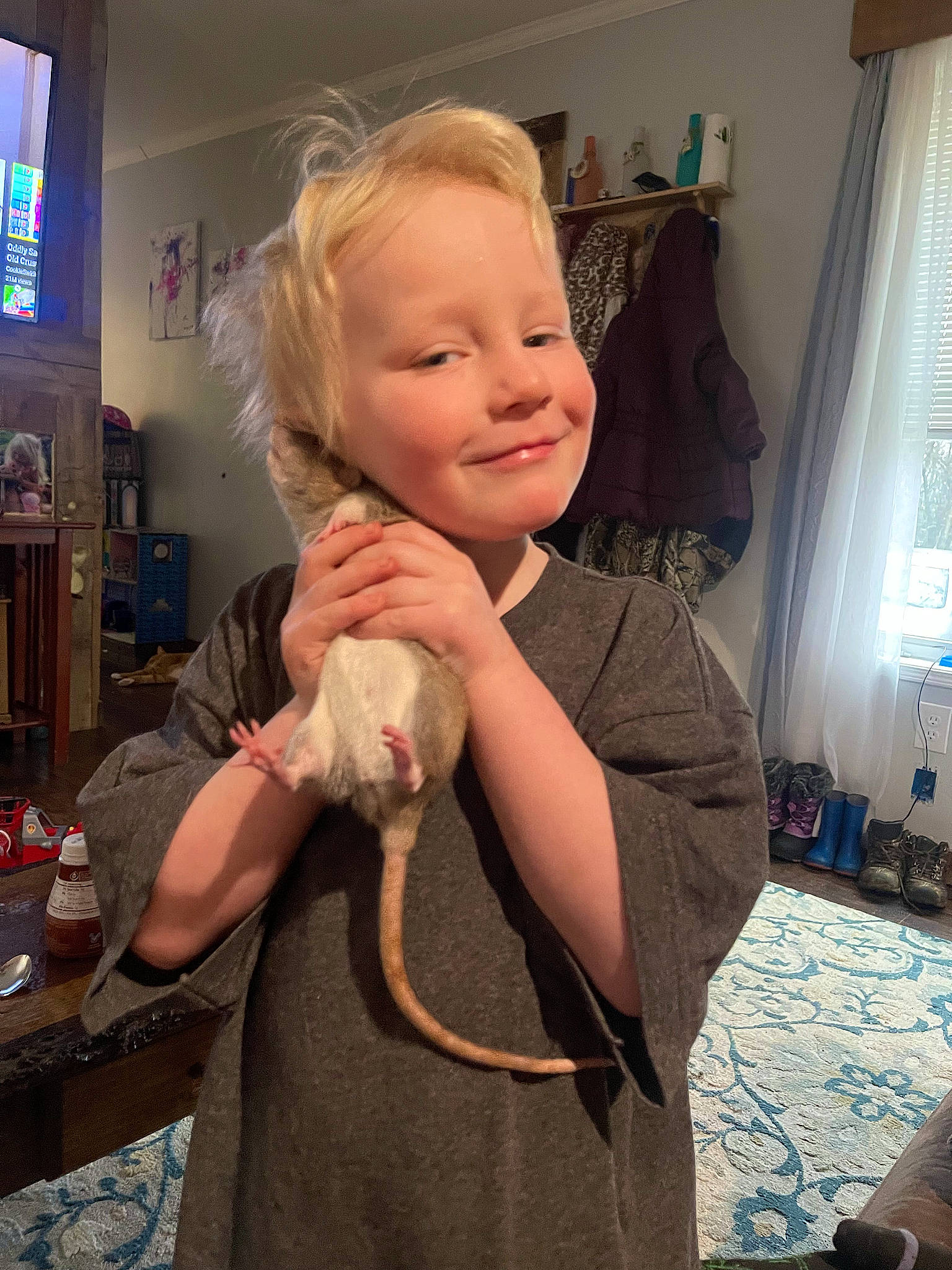 James joined the competition — help win amazing prizes! blond, child, curtain, fashion_accessory, flooring, fun, fur, gesture, happy, joy, person, picture_frame, room, sitting, sleeve, smile, television, thumb, toddler, window