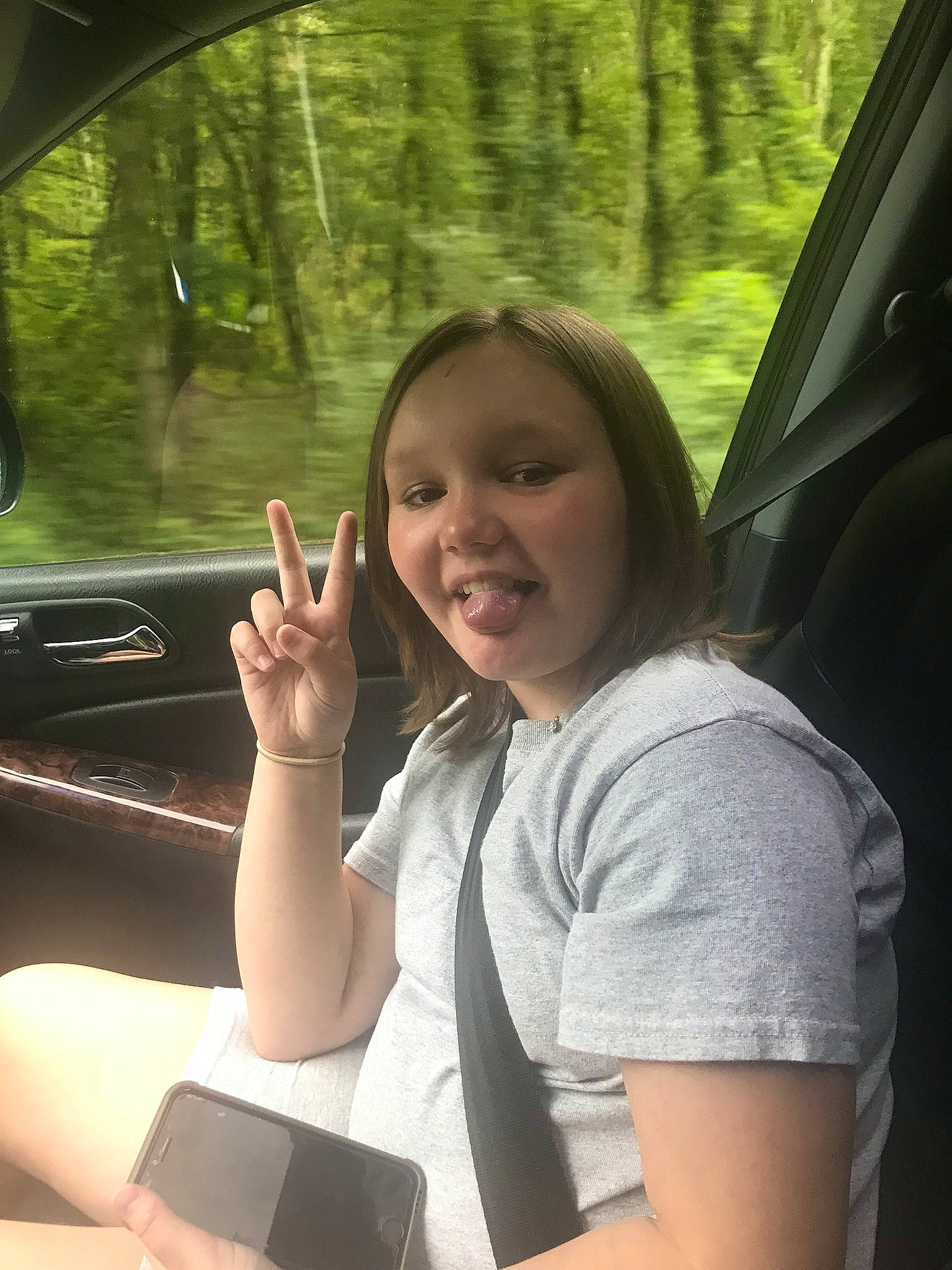 Dakota is registered to the contest to win money with this photo: auto_part, automotive_design, automotive_exterior, automotive_mirror, beauty, elbow, finger, gesture, happy, joy, leisure, motor_vehicle, person, personal_luxury_car, rear_view_mirror, steering_part, steering_wheel, tints_and_shades, tree, vehicle_door