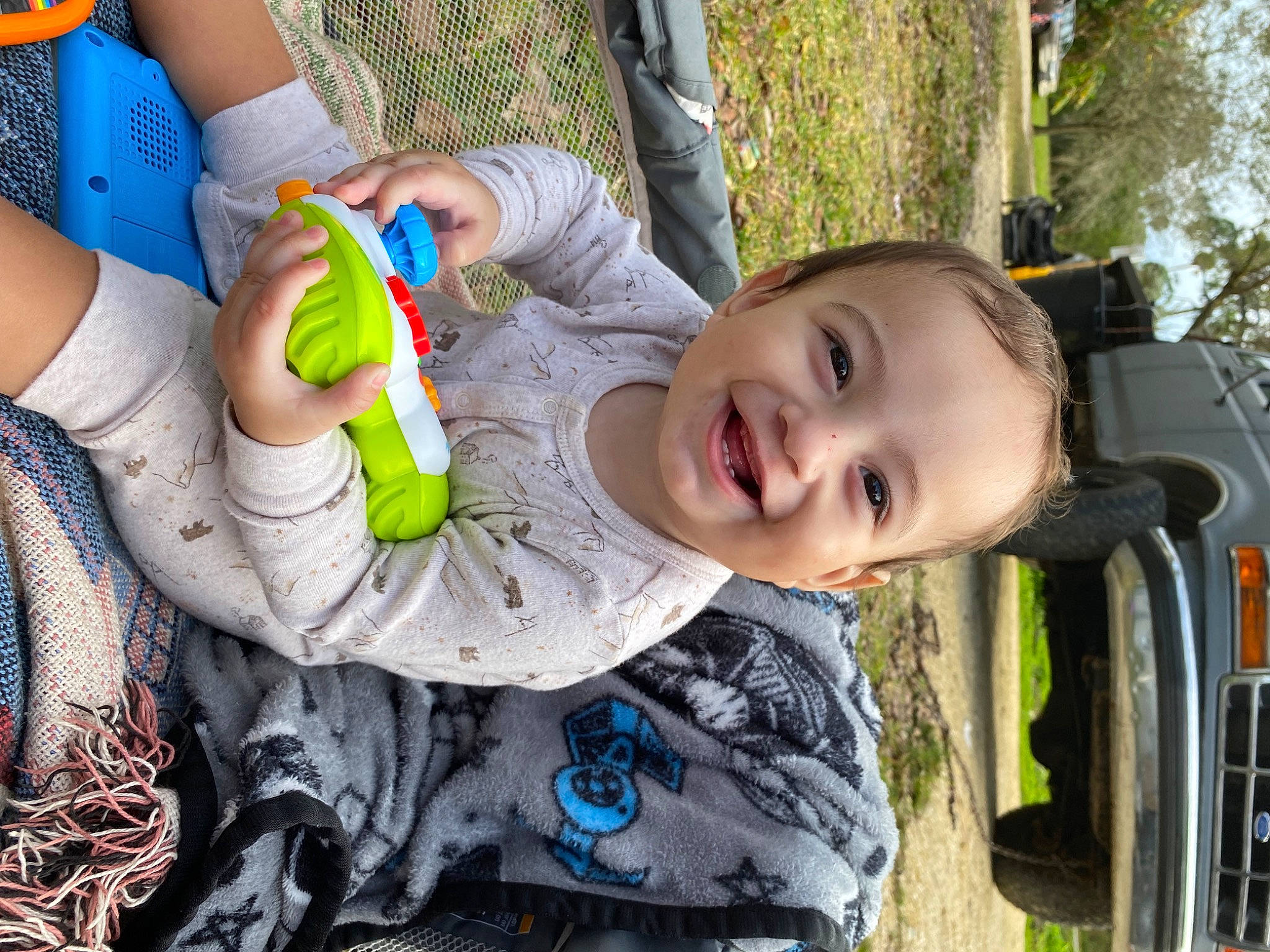 Elijah is registered to the contest to win money with this photo: baby, baby_products, beauty, child, event, facial_expression, fun, grass, hand, happy, joy, leisure, motor_vehicle, person, plant, play, recreation, sitting, skin, smile