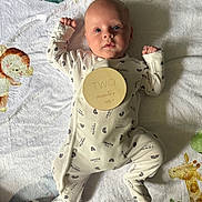 Beau is registered to the contest to win money with this photo: baby, infant, two_months, onesie, blanket, animal_print, lion, giraffe, soft_toys, cute, lying_down, curious, child, newborn, sleepwear, patterned_clothing, baby_girl, baby_boy, indoors, portrait