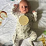 baby, infant, two_months, onesie, blanket, animal_print, lion, giraffe, soft_toys, cute, lying_down, curious, child, newborn, sleepwear, patterned_clothing, baby_girl, baby_boy, indoors, portrait